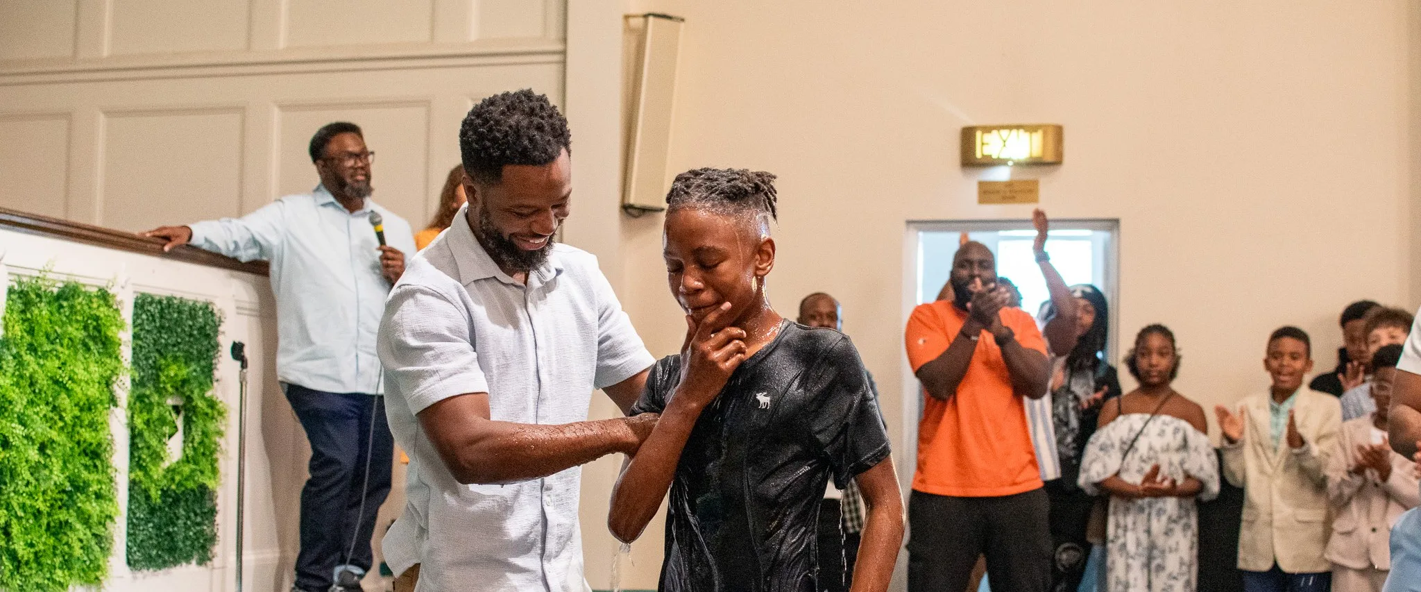 The church cheering as a young man celebrates his baptism