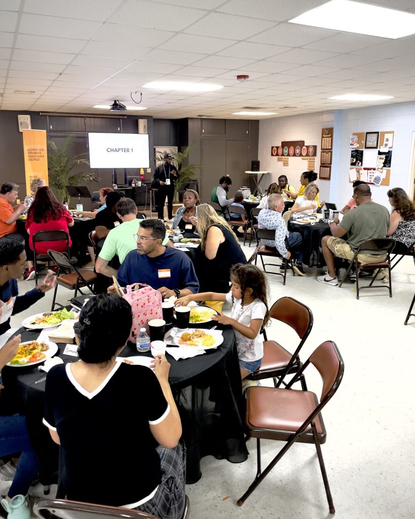 Guests sharing lunch at round tables during ONE Weekend