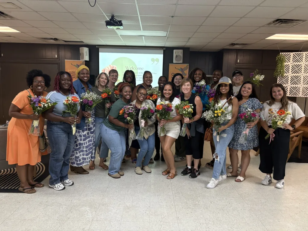 Women holding flower bouquets at a One Family Church women's gathering